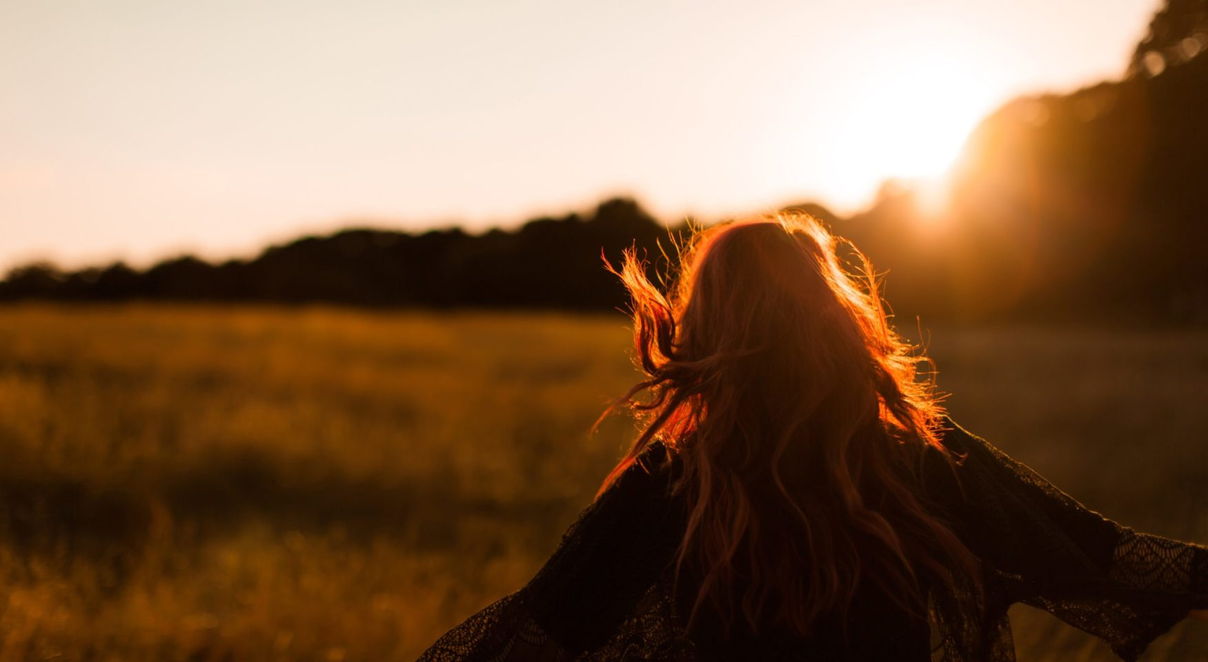 woman in field at sunset